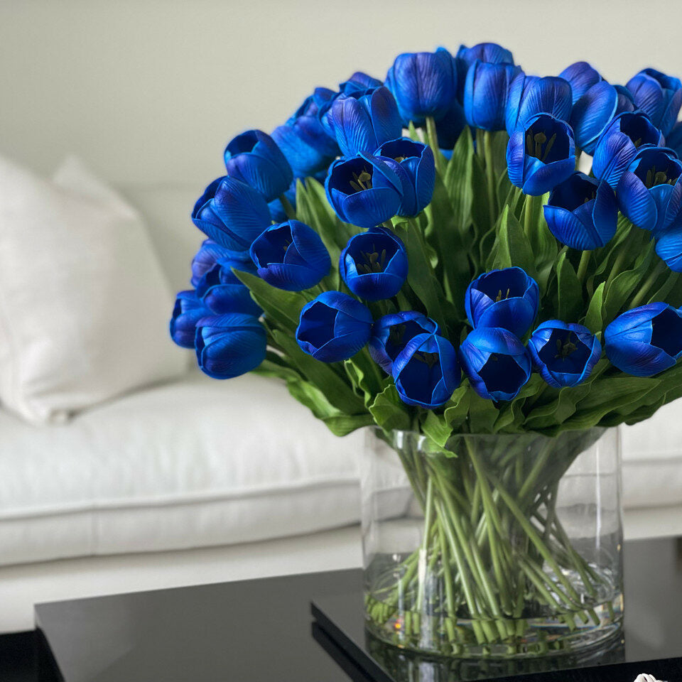 Arrangement of blue tulips in a large cylindrical vase